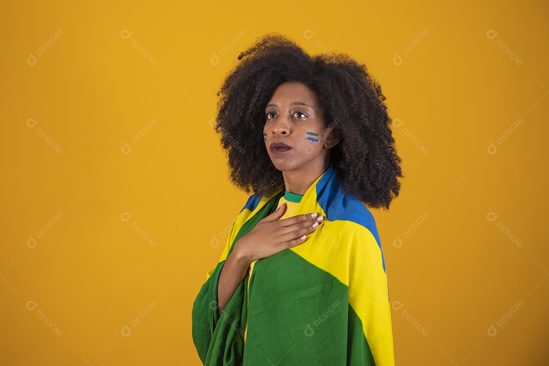 Linda mulher torcedora brasileira cabelo cacheado sobre fundo isolado amarelo