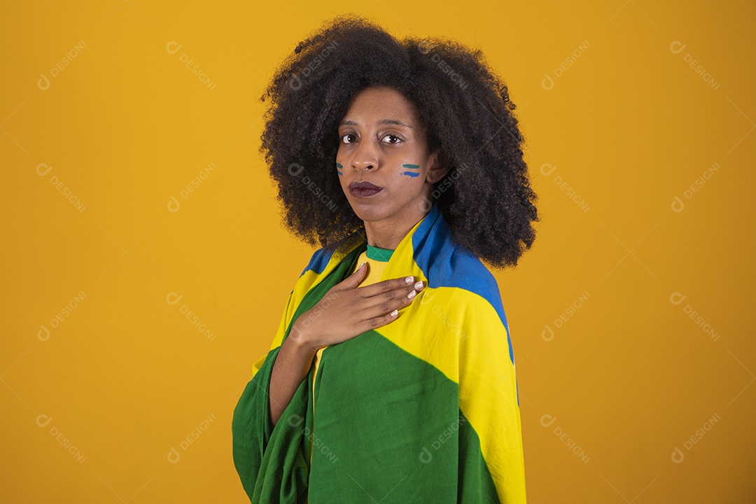 Linda mulher torcedora brasileira cabelo cacheado sobre fundo isolado amarelo