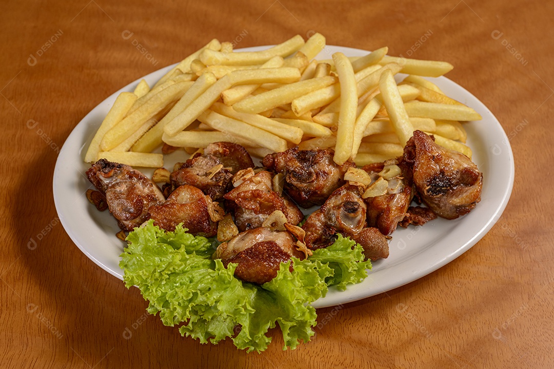 Prato de frango frito brasileiro cozido com alho e salsa com batatas fritas.