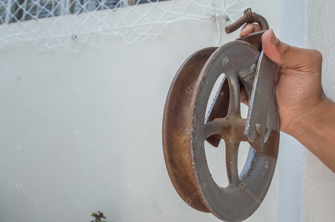 Polia velha feita de ferro com uma mão segurando