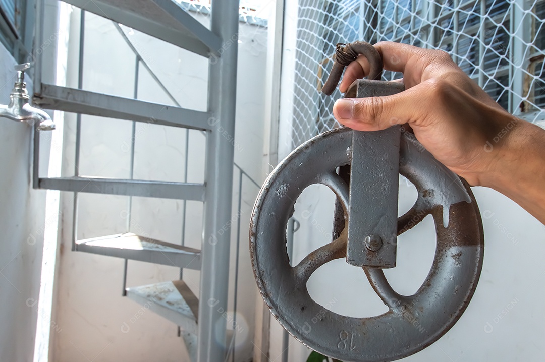 Polia velha feita de ferro com uma mão segurando