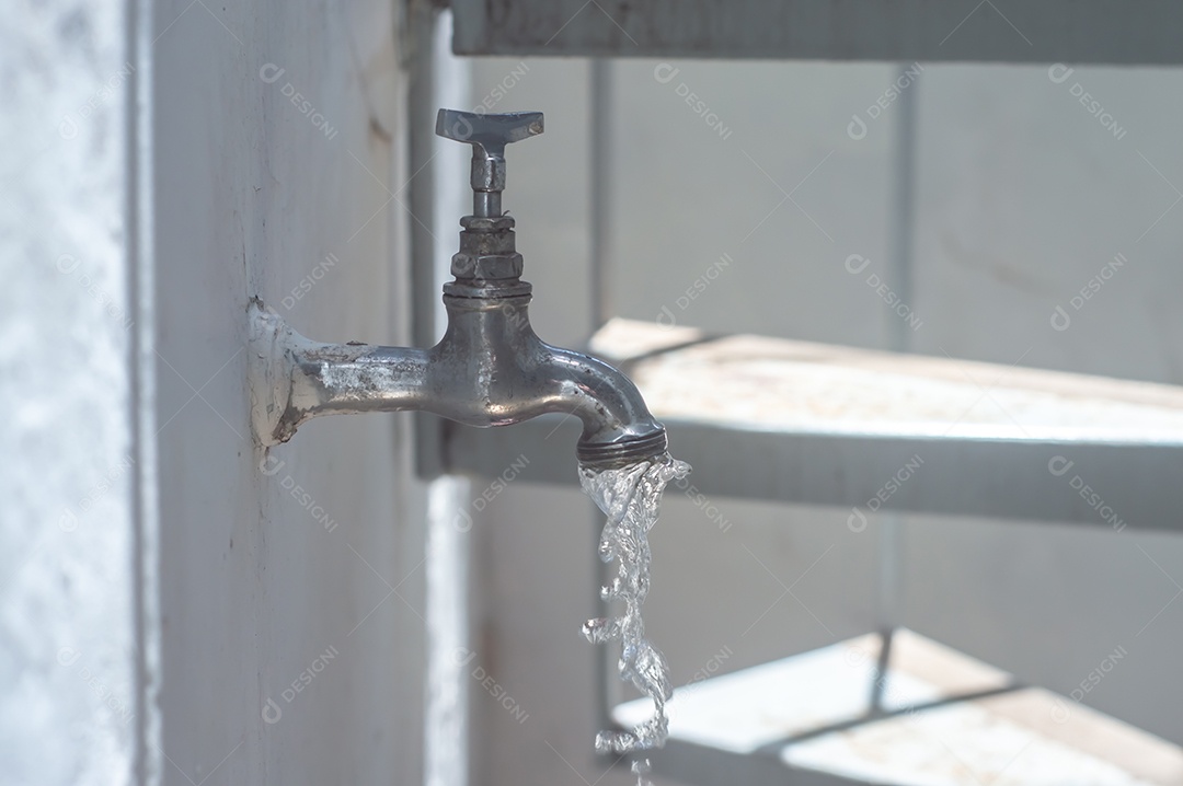 Torneira Vintage antiga e usada com gota de água, luz natural.