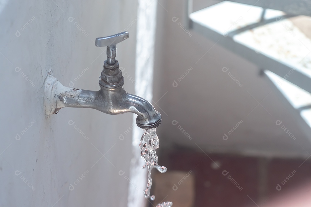 Torneira Vintage antiga e usada com gota de água, luz natural.