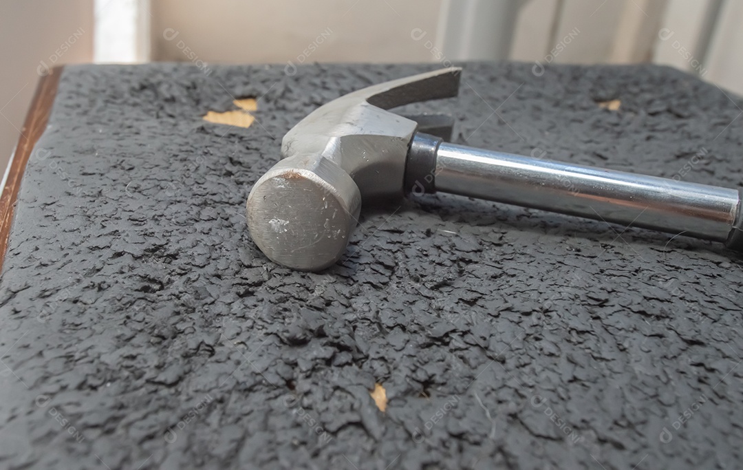 Martelo com cabo preto à esquerda, conceito de manutenção