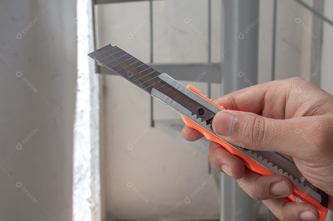 Mão seca segurando cortadores de caixa e fatiando.