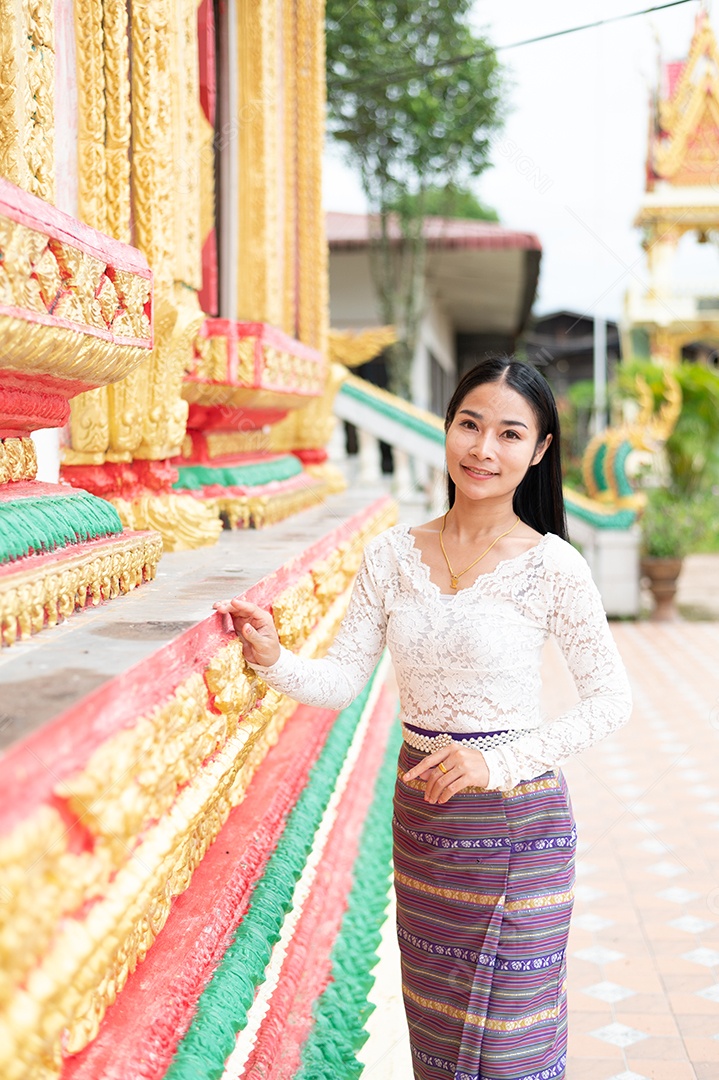 Mulher Tailandesa vestida em traje tradicional da Tailândia em templo