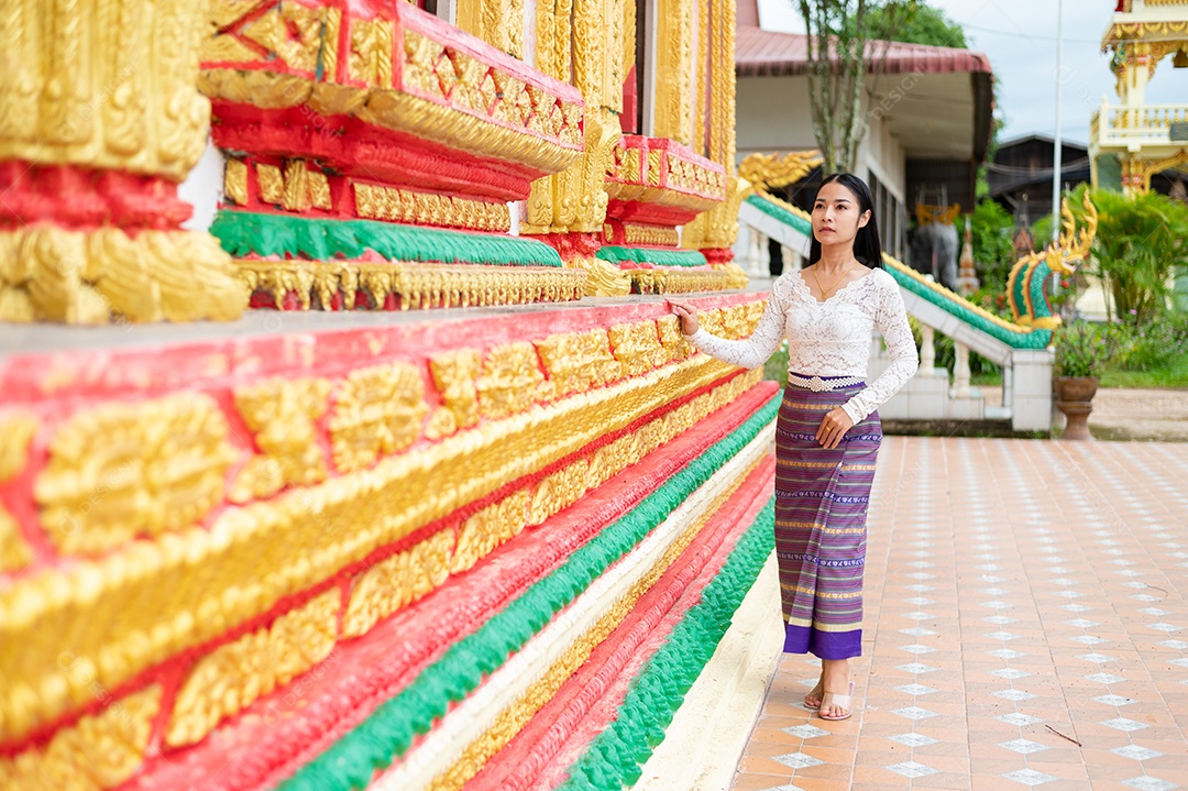 Mulher Tailandesa vestida em traje tradicional da Tailândia em templo
