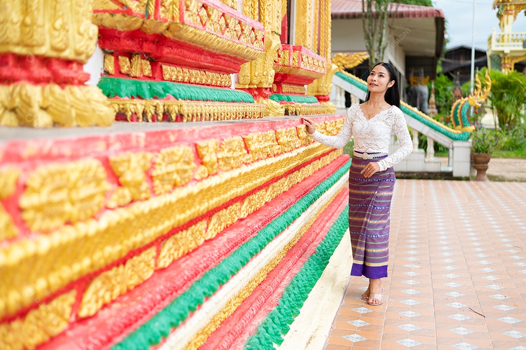 Mulher Tailandesa vestida em traje tradicional da Tailândia em templo