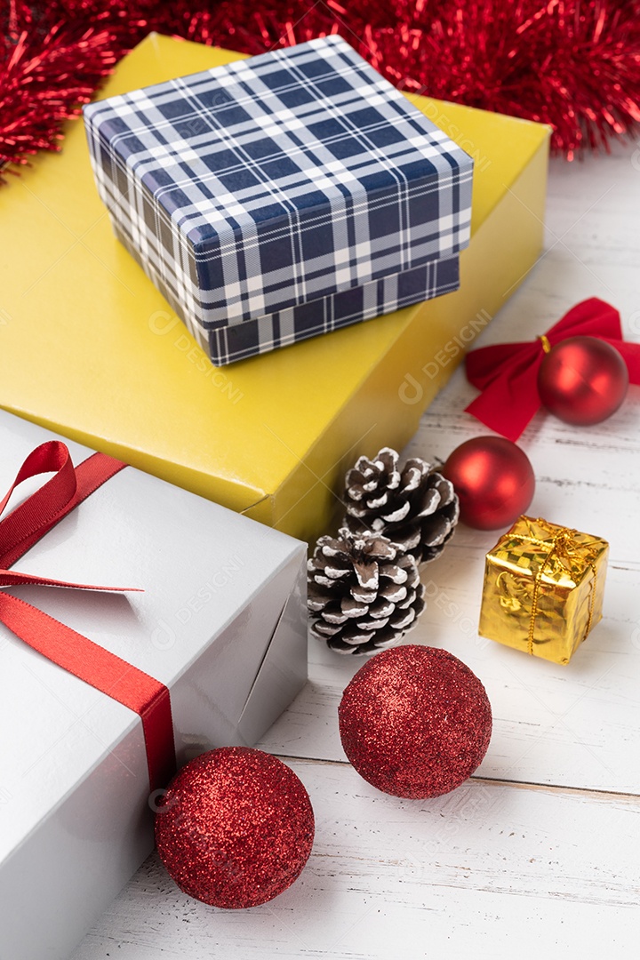 Caixa de presente, bolas de natal e arco sobre a mesa de madeira.