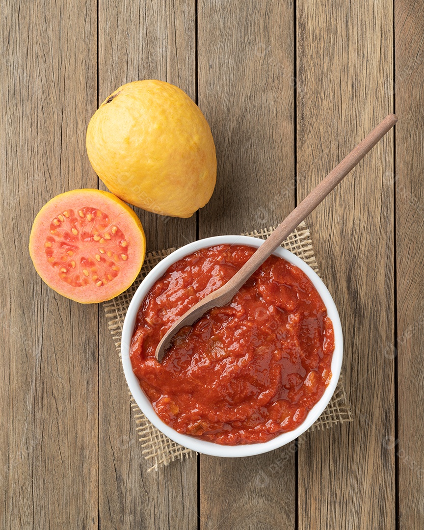 Goiabada, doce de goiaba cremosa brasileira tradicional com frutas sobre a mesa de madeira.