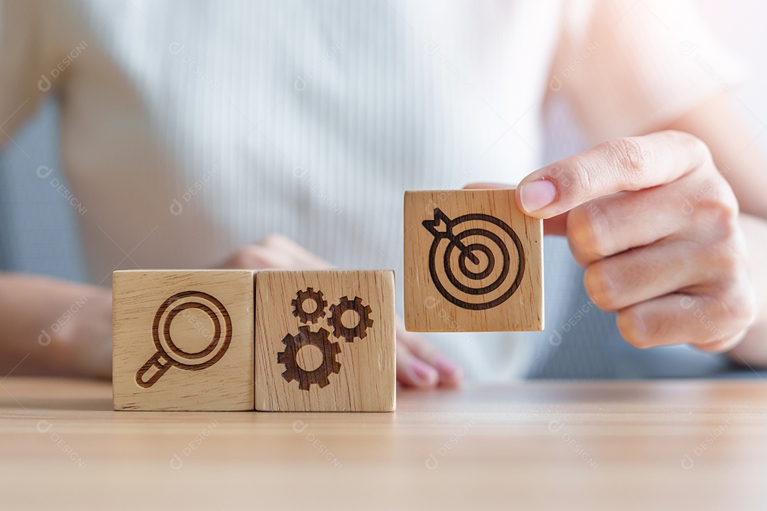 Mão de uma mulher segurando o alvo de dardos, bloco de ícone de engrenagem e lâmpada