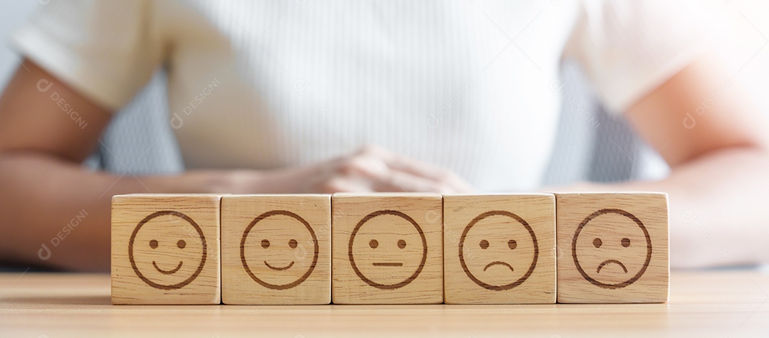 Mão escolhendo rosto sorridente do bloco Emoção. avaliação do cliente