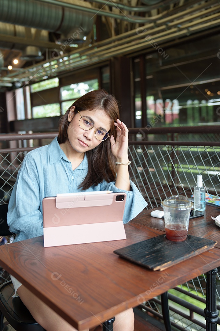 Mulher asiática feliz usando tablet de computador no café