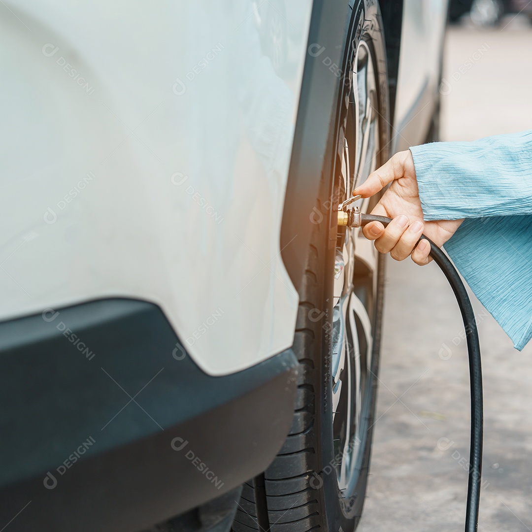 Driver man hand inflating vehicle tires by removing tire valve