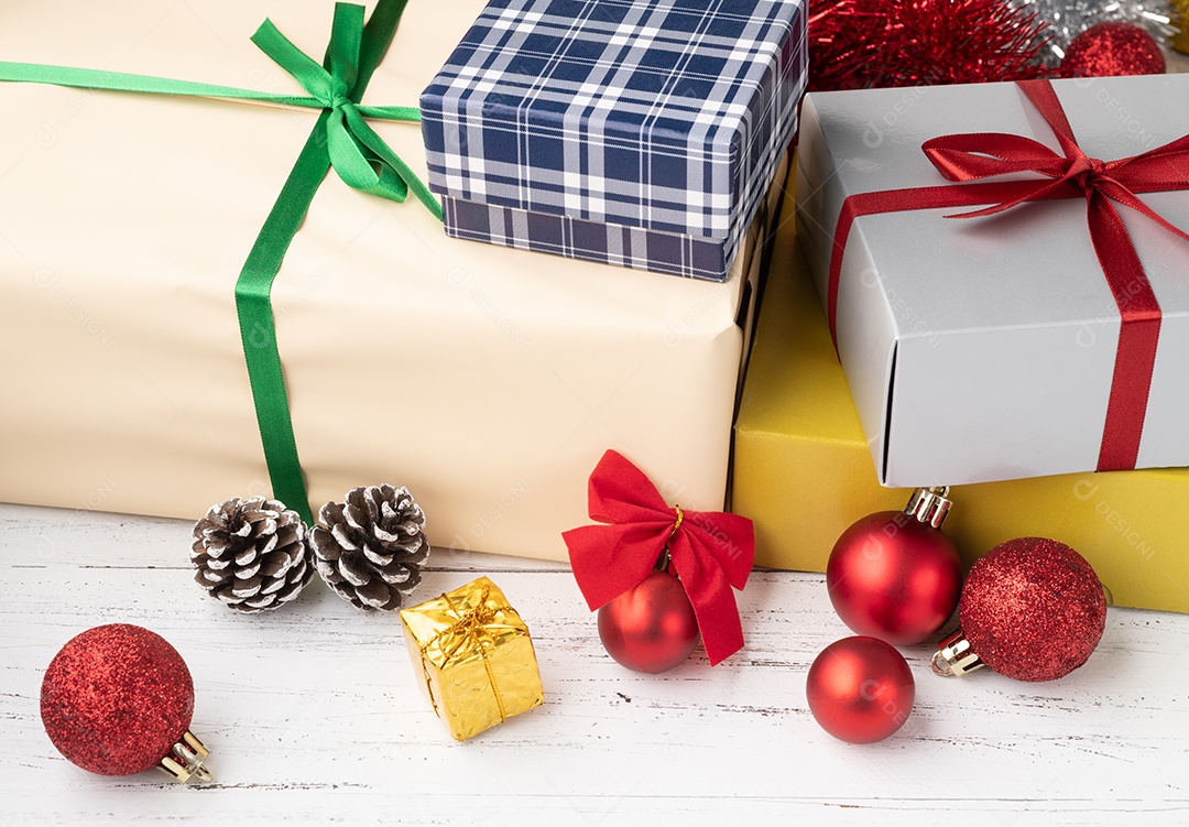 Caixa de presente, bolas de natal e arco sobre a mesa de madeira.