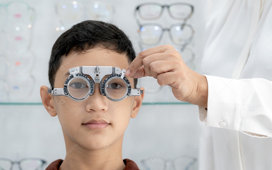 Menino tem seus olhos verificados por óculos por um especialista.