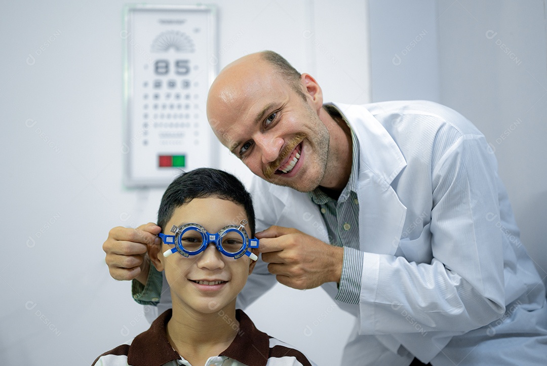 Um oftalmologista usa óculos de teste ocular para testar lentes adequadas em meninos, visão frontal de close-up com foco em meninos.