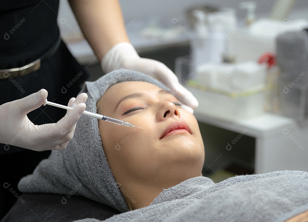 Uma jovem injeta vitaminas no rosto em uma clínica de beleza.