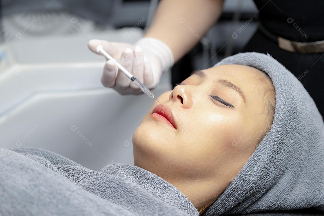 Uma jovem injeta vitaminas no rosto em uma clínica de beleza.