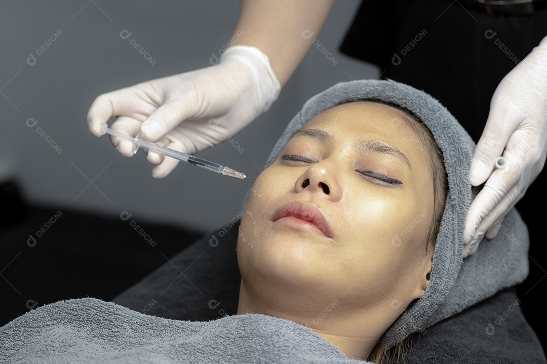 Uma jovem injeta vitaminas no rosto em uma clínica de beleza.