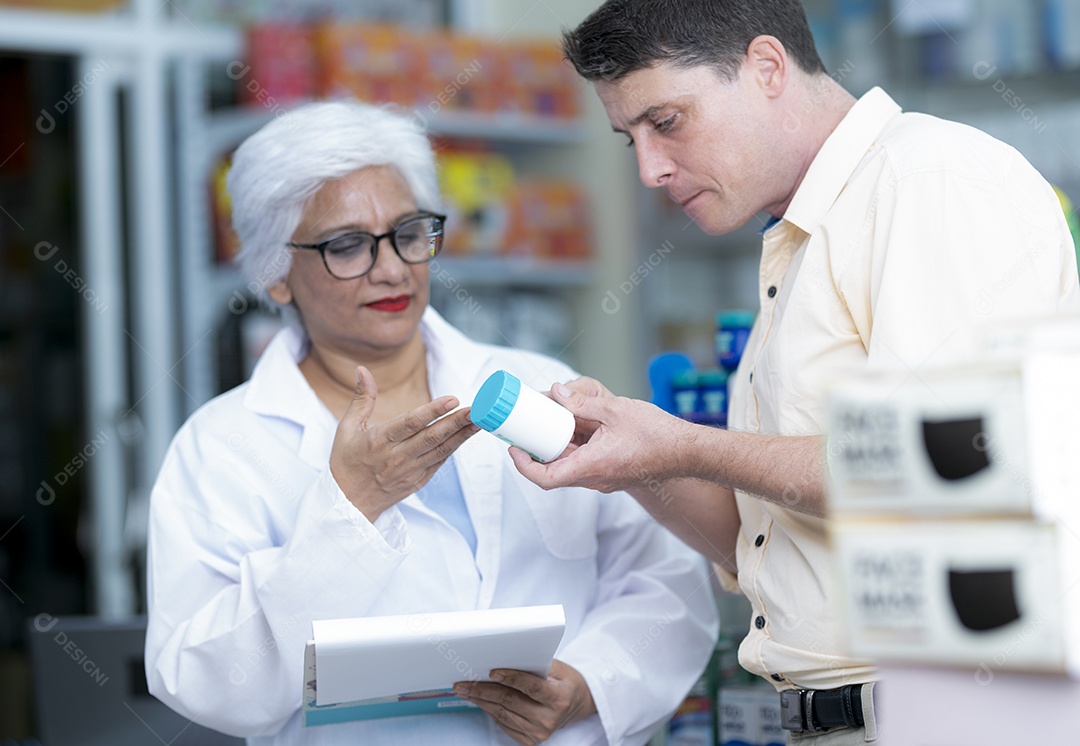 Elderly Asian Indian female pharmacist advise Caucasian male medicine to treat disease, experts recommend medicine.