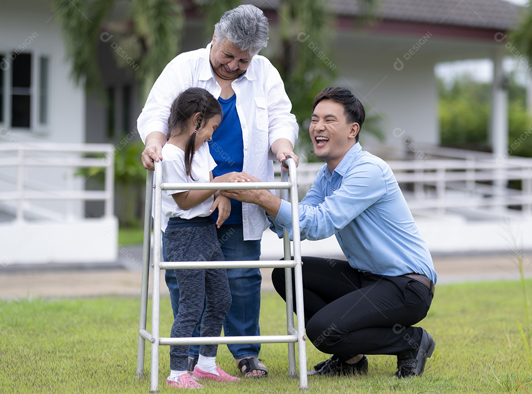 Um jovem asiático e uma mulher cuidando de uma idosa em uma casa de repouso, filho e neta provocam a avó do Oriente Médio com ajuda para caminhar, caer de enfermagem.