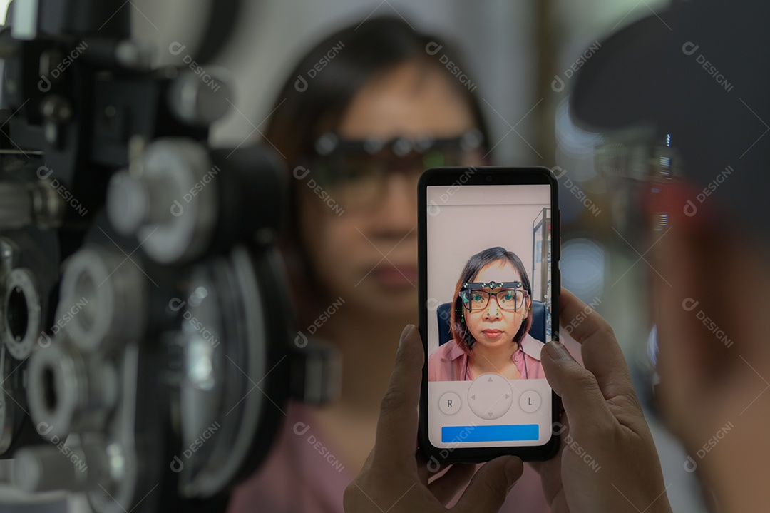 Oftalmologistas usam aplicativo de smartphone para medir parâmetros para fabricação de lentes de óculos, novo aplicativo de optometria, rosto de close-up com foco na tela do telefone, loja de óptica.