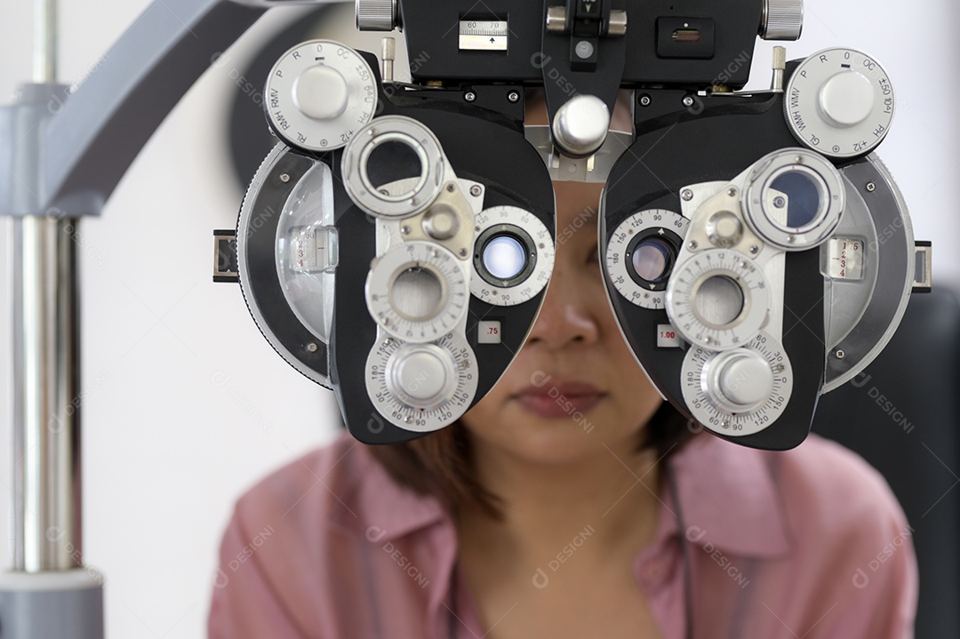 Asian woman examines the eyes with a machine from a specialist, an optician shop.