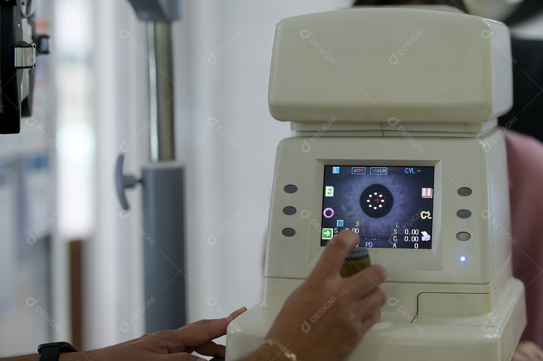 Mulher asiática examina os olhos com uma máquina de um especialista, uma loja de óptica.