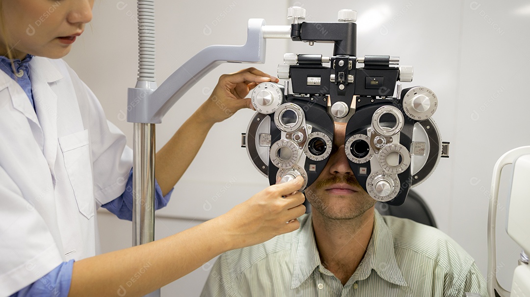 Oftalmologista feminina asiática testa olhos de pacientes do sexo masculino caucasianos com máquina especial, foco de perto na máquina, conceito de cuidados com os olhos.