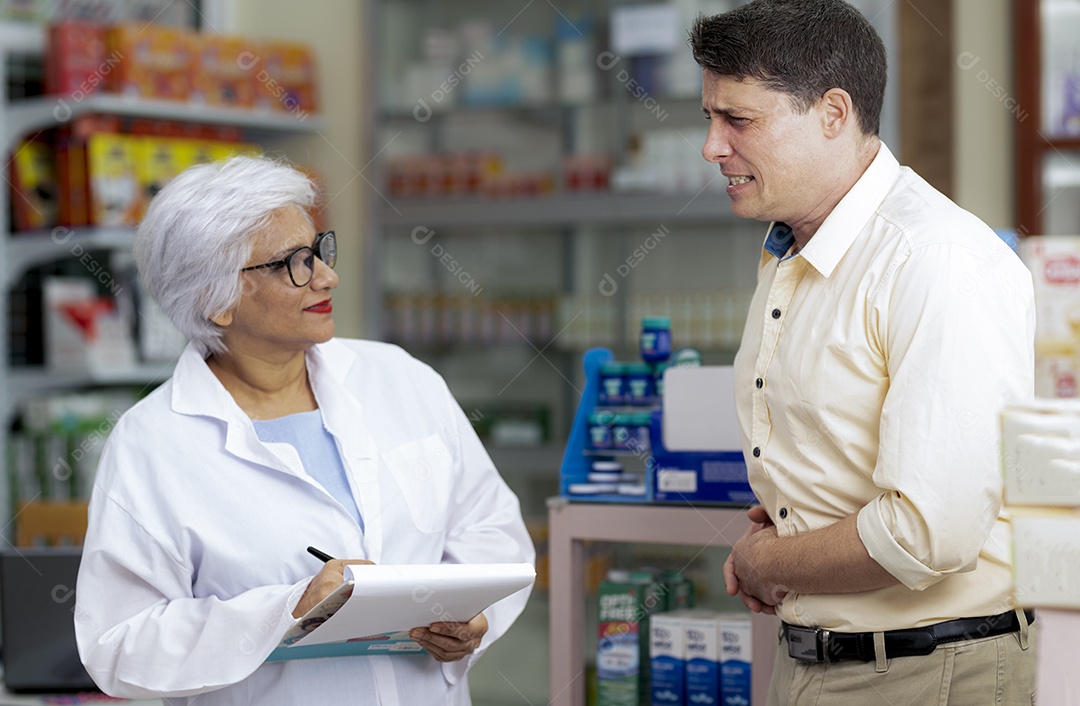 Um jovem caucasiano consulta um farmacêutico sobre sua doença. uma especialista médica indiana pede a um homem caucasiano que recomende e prescreva medicação, vista lateral e tiro da cintura para cima.