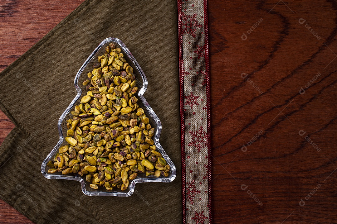 Vasilha em forma de árvore de Natal cheia de pistache. Vista do topo