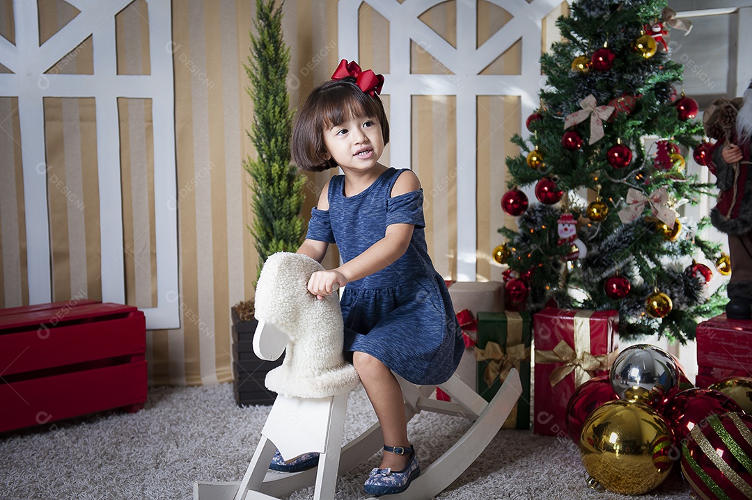 Retrato de menina bonita na época do Natal. Decoração de Natal ao fundo.
