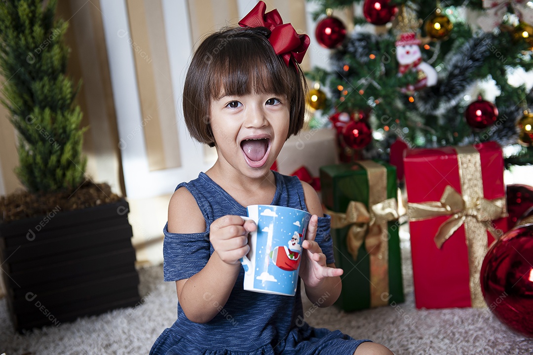 Retrato de menina bonita na época do Natal. Decoração de Natal ao fundo.