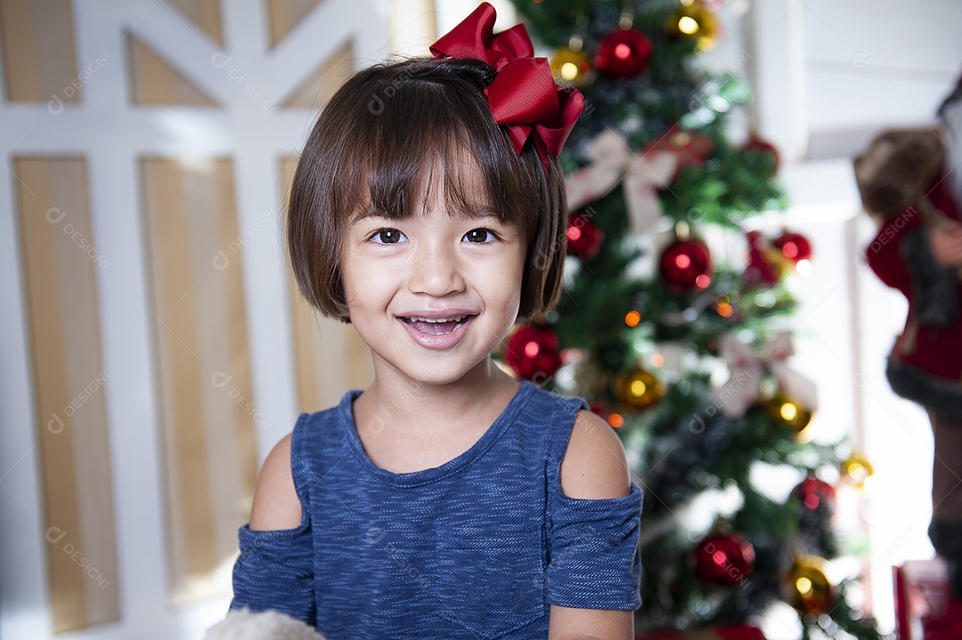 Retrato de menina bonita na época do Natal. Decoração de Natal ao fundo.