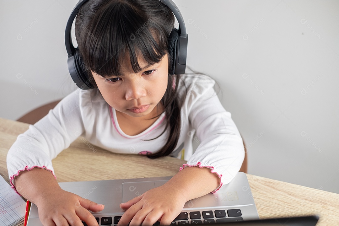 4-5 years old Asian girl wearing white shirt is studying online