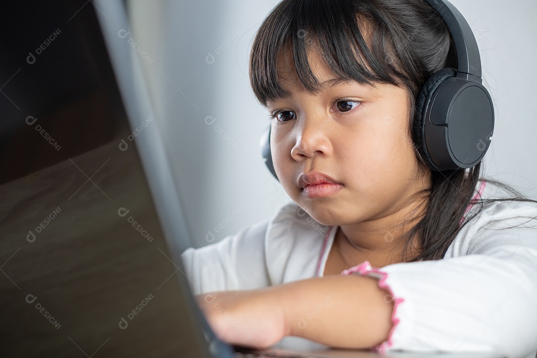 Menina asiática de 4-5 anos vestindo camisa branca está estudando online