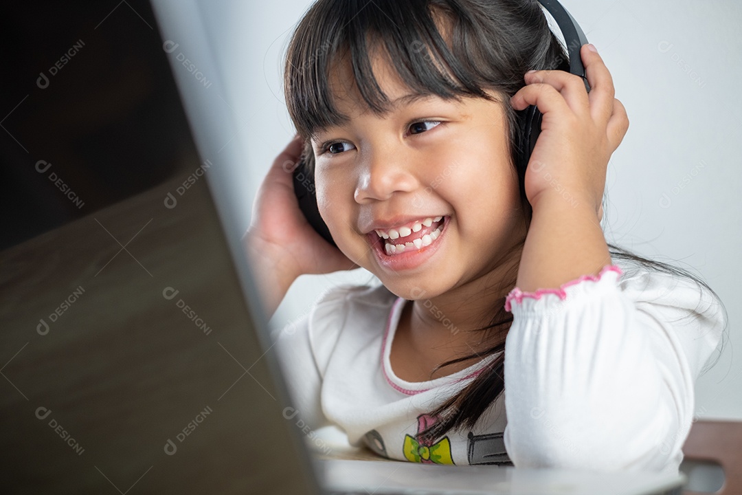 Menina asiática de 4-5 anos vestindo camisa branca está estudando online