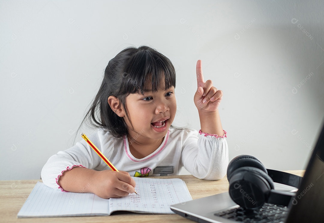 Menina asiática de 4-5 anos vestindo camisa branca está estudando online
