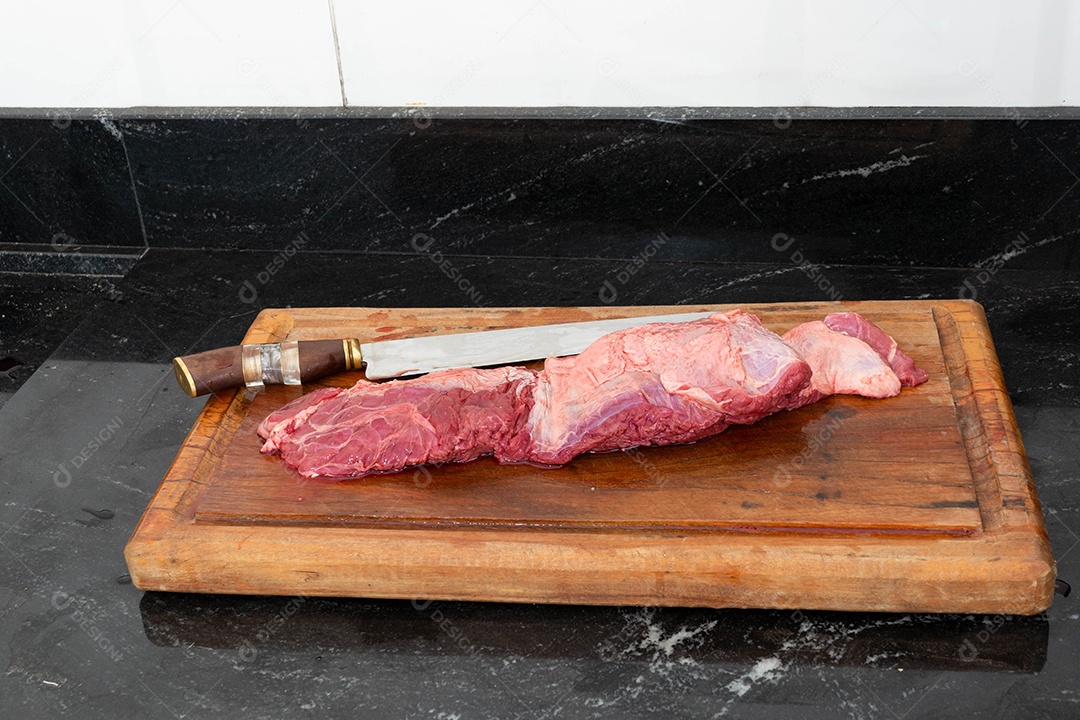 Fraldinha brasileira, carne crua e vermelha em uma tábua, preparando-se para o churrasco.