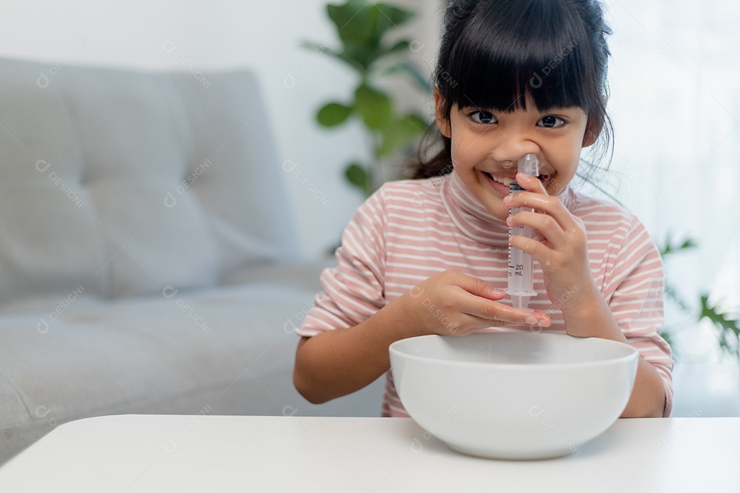 Nariz de lavagem nasal salina menina asiática em casa.