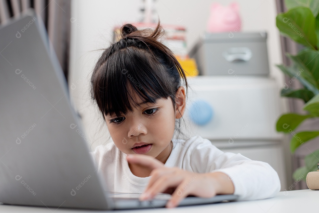 Aluna asiática fazendo sua lição de casa com o laptop em casa.