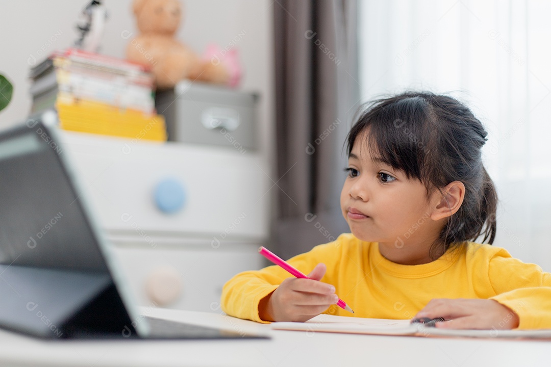 Aluna asiática fazendo sua lição de casa com tablet digital em casa.