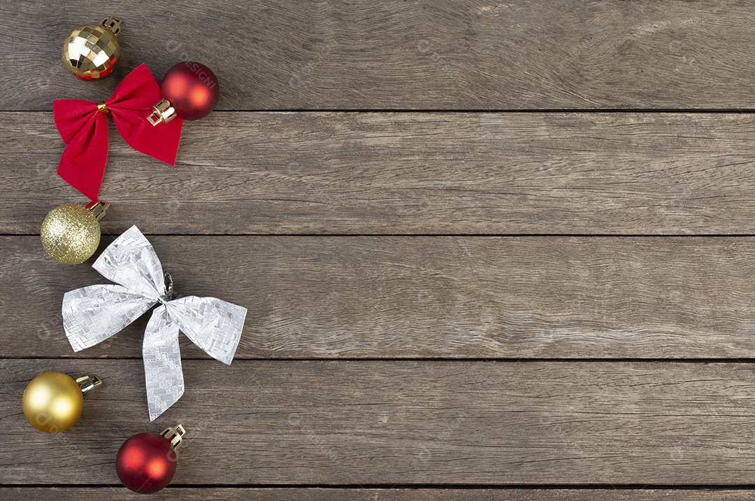 Bolas de natal vermelhas, douradas e prateadas e laços de presente sobre madeira