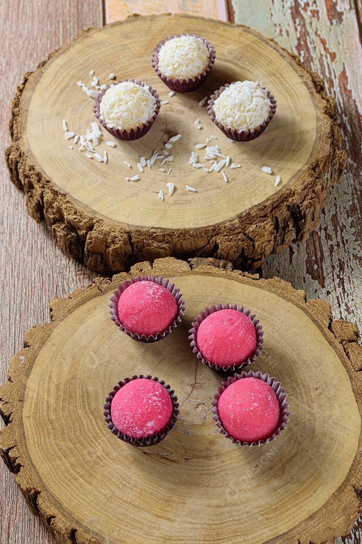 Brigadeiros de Morango Bicho de Pe em pratos de tronco de árvore