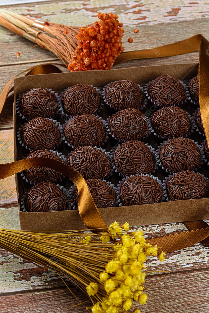 Detalhe de brigadeiro de morango cercado por brigadeiros tradicionais