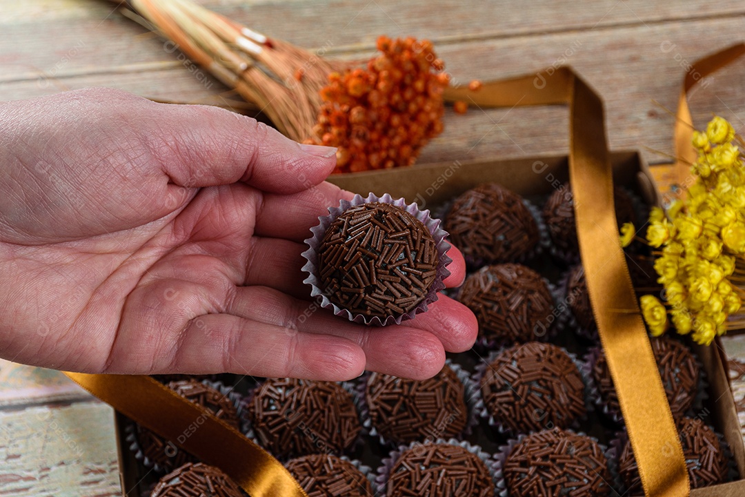 Brigadeiro de morango cercado por brigadeiros tradicionais brigadeiros