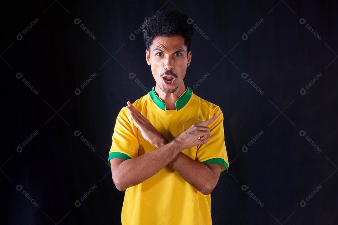 Jogador negro de futebol brasileiro comemorando, isolado em fundo preto.