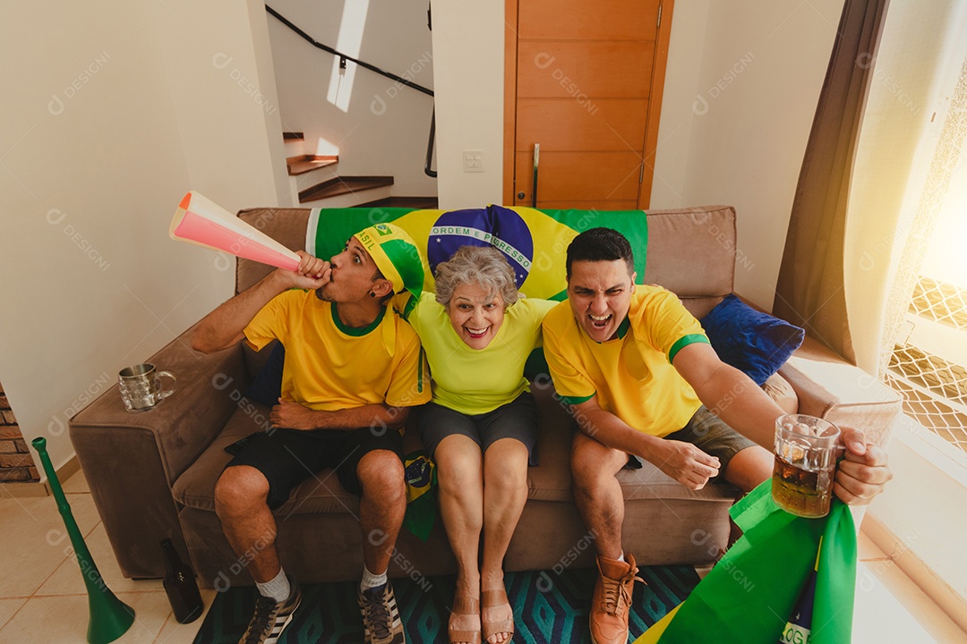 Família mestiça brasileira Comemorando a copa na sala assistindo jogo de futebol.