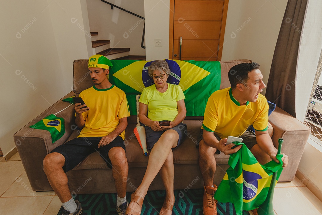 Família mestiça brasileira Comemorando a copa na sala assistindo jogo de futebol.